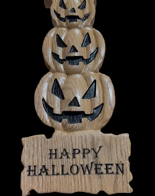 Oak stacked pumpkins with happy halloween carved in black lettters 